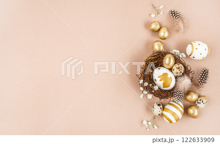 Easter eggs in a nest on beige background. Stylish golden eggs. Happy Easter card. top view. copy space Easter eggs in a nest on beige background. Stylish golden eggs. Happy Easter card. top view. copy space 122633909