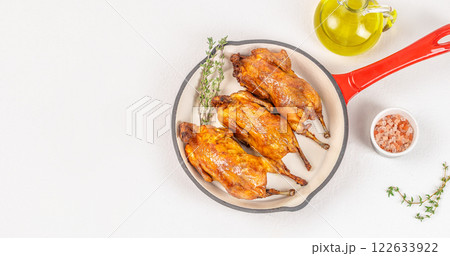 quail Baked quails in pan Cooked on a white background top view. copy space 122633922