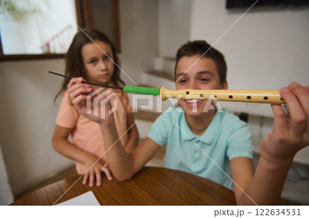 Two children exploring a recorder instrument at home Two children exploring a recorder instrument at home 122634531