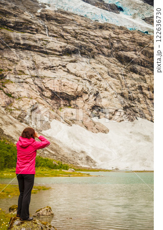 Tourist admiring Boyabreen Glacier in Norway 122636730