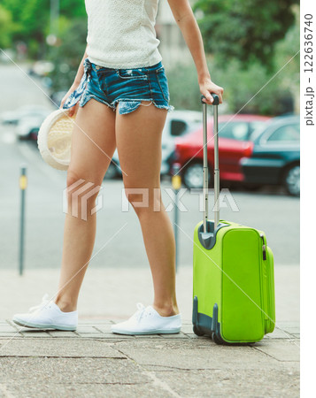 Part body of female tourist with suitcase. Part body of female tourist with suitcase. 122636740