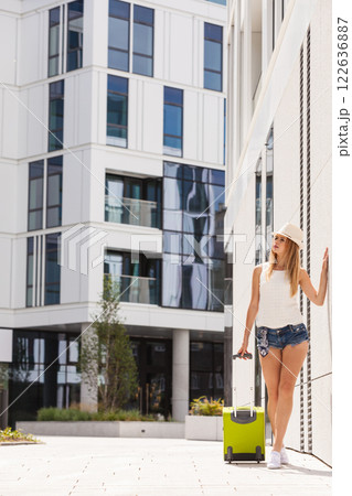 Attractive woman with suitcase walking after arrival Attractive woman with suitcase walking after arrival 122636887