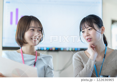 資料を持ちながら打合せをする若いビジネスウーマン 資料を持ちながら打合せをする若いビジネスウーマン 122636965