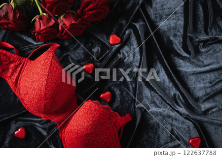 Lace women's red underwear, lingerie, chocolate candy sweets and red roses for Valentine's day on dark. Romantic dating. View from above. Copy space. Lace women's red underwear, lingerie, chocolate candy sweets and red roses for Valentine's day on dark. Romantic dating. View from above. Copy space. 122637788