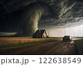tornado in a field in the USA with wooden house and car on road under stormy dark sky 122638549