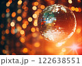 A disco ball is suspended from the ceiling at party, reflecting the lights 122638551