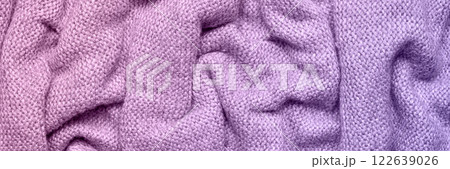A soft and textured gradient lilac and purple knitted fabric with gentle waves and folds, creating a cozy and warm appearance. Ideal for textile backgrounds, fashion, or home decor themes. A soft and textured gradient lilac and purple knitted fabric with gentle waves and folds, creating a cozy and warm appearance. Ideal for textile backgrounds, fashion, or home decor themes. 122639026