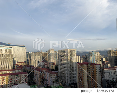 Cityscape of Batumi from high floor overlooking old district. Large residential area with tall houses and mountains in background in Georgia. Urban development with residential buildings Cityscape of Batumi from high floor overlooking old district. Large residential area with tall houses and mountains in background in Georgia. Urban development with residential buildings 122639478