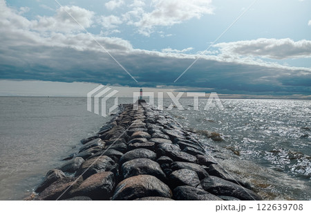 A lighthouse stands on a rock in front of the sea 122639708
