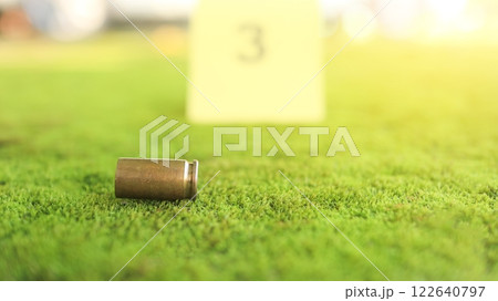 A spent bullet casing in focus, with a blurred forensic number 3 tag behind it, symbolizes crime scene investigation, evidence collection, and law enforcement efforts in forensic science. A spent bullet casing in focus, with a blurred forensic number 3 tag behind it, symbolizes crime scene investigation, evidence collection, and law enforcement efforts in forensic science. 122640797
