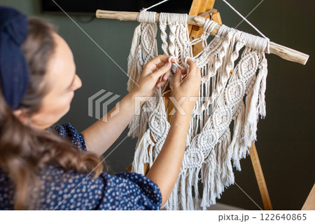 Smiling Woman Crafting Macrame Wall Hanging at Home 122640865