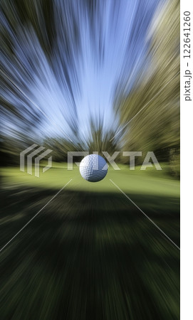 Golf ball speeding through a lush golf course during a vibrant tournament day 122641260