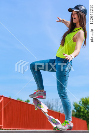 Teen girl skater riding skateboard on street. 122642219