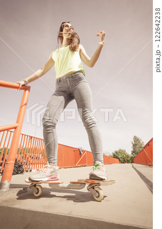 Teen girl skater riding skateboard on street. 122642238