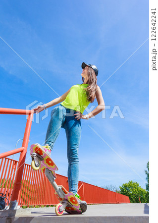 Teen girl skater riding skateboard on street. 122642241