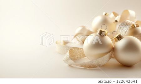 Champagne-colored Christmas tree ornaments with gold ribbons, arranged on a cream-to-white gradient background Champagne-colored Christmas tree ornaments with gold ribbons, arranged on a cream-to-white gradient background 122642641