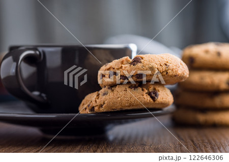 Chocolate chip cookies and coffee cup on wooden table. 122646306