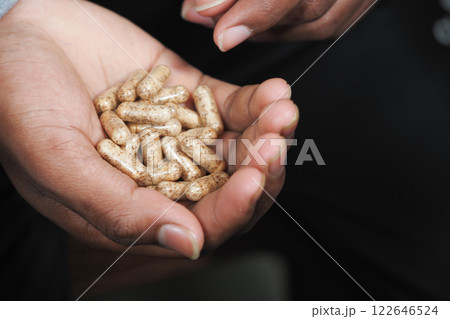 Natural supplements held in open hand during wellness demonstration Natural supplements held in open hand during wellness demonstration 122646524