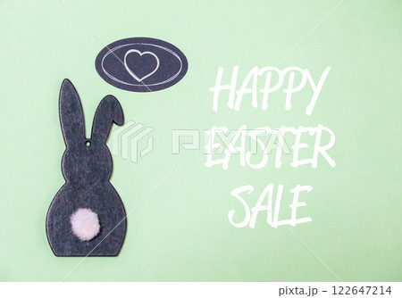 Rabbit is sitting on a green background with a heart in the middle 122647214