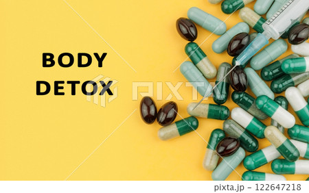 Bunch of pills with a syringe on top of them and the words body detox below Bunch of pills with a syringe on top of them and the words body detox below 122647218