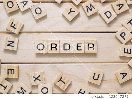 Wooden board with a bunch of wooden letters scattered around it 122647271