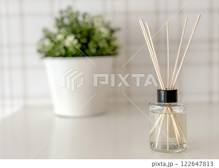 A small vase with a plant in it sits on a table. 122647813