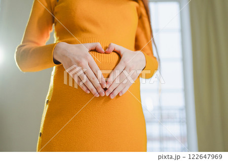 Pregnancy motherhood expectation future. Pregnant woman hands touching big belly. Girl making heart shape with hands enjoying pregnancy. Pregnant woman showing heart sign. Maternity love new life 122647969