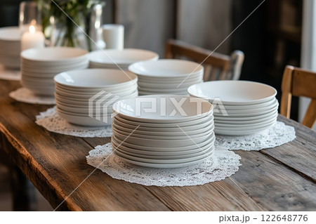 Elegant dining setup with stacked plates on a rustic wooden table Elegant dining setup with stacked plates on a rustic wooden table 122648776