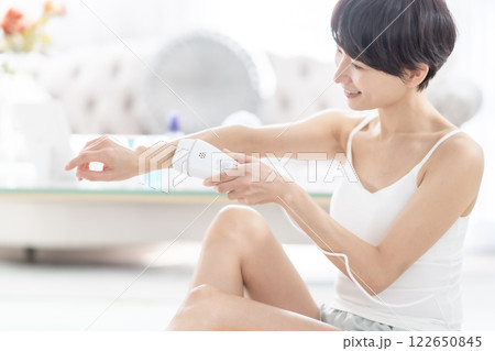 腕に光脱毛気を当てる女性　顔無し 122650845