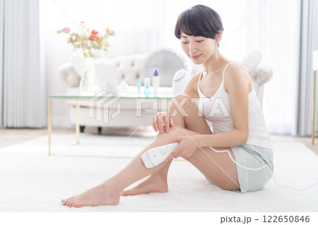 足に光脱毛気を当てるミドルの女性 122650846