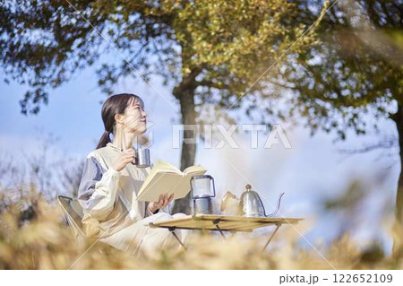 冬の屋外のテーブルで本を読む女性 冬の屋外のテーブルで本を読む女性 122652109