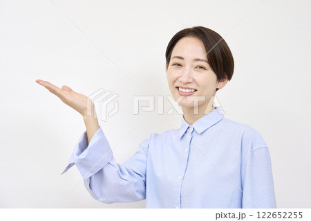 手のひらで左を指す女性　白背景 122652255