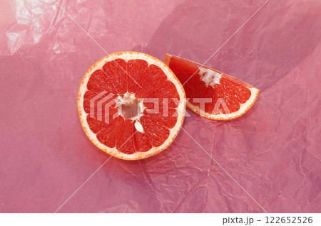 Sliced grapefruit on pink paper background. 122652526