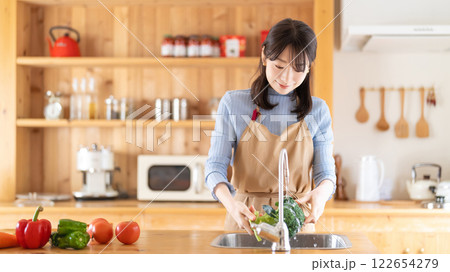 キッチンで料理をする女性（野菜を洗う） 122654279