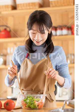 キッチンで料理をする女性（サラダを作る） 122654281
