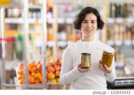Adult woman choosing olives in grocery store 122654531