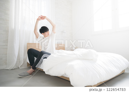 朝日を浴びるベッドで寝起きの若い男性の広角 よく寝た~ 朝日を浴びるベッドで寝起きの若い男性の広角 よく寝た~ 122654783