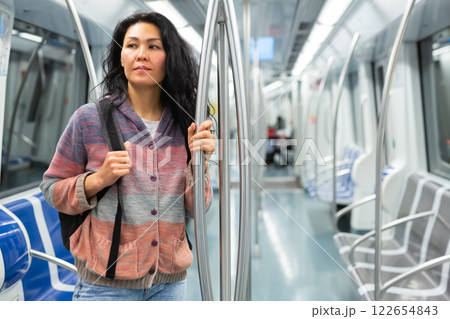 Young woman passenger sitting in subway car 122654843