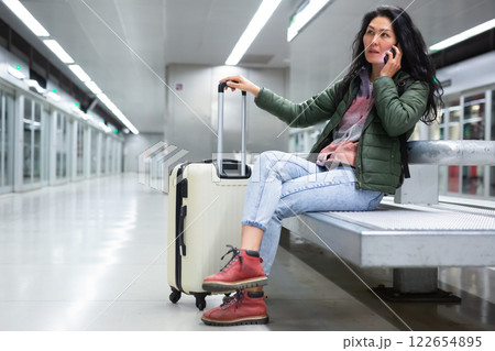 Female passenger waiting train at subway station Female passenger waiting train at subway station 122654895