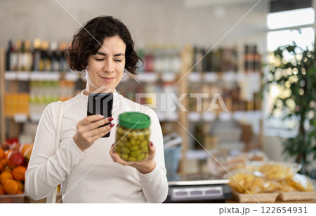 Adult woman scanning qr code of olives Adult woman scanning qr code of olives 122654931