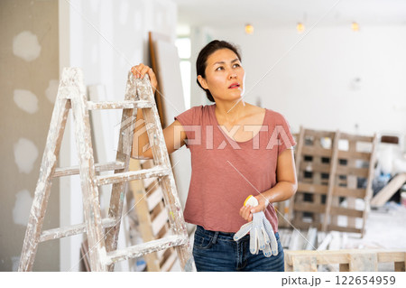 Thoughtful woman in apartment during renovation Thoughtful woman in apartment during renovation 122654959
