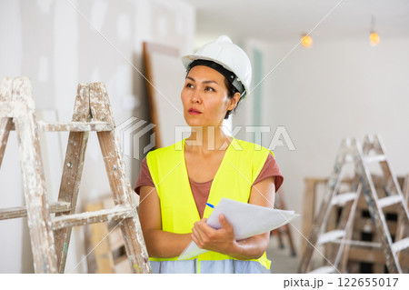 Woman builder checking project documentation 122655017
