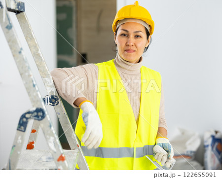 Portrait of female builder with construction painting tools 122655091