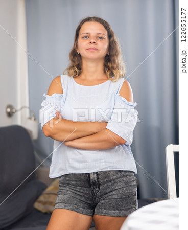 Girl dressed tee-shirt and tight shorts in at room Girl dressed tee-shirt and tight shorts in at room 122655177