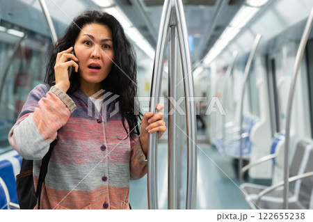 Woman having phone talk in subway car 122655238