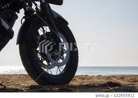 千里浜なぎさドライブウエイで砂浜の上をバイクで走る 122655911