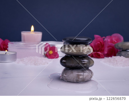 Shower gel flowing on spa stones with body care products, flowers and candles 122656870