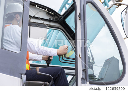 クレーンを操縦する男性の手元 122659200