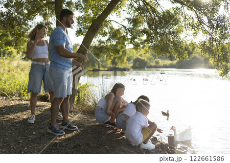 Family enjoying a relaxing day by the lake Family enjoying a relaxing day by the lake 122661586