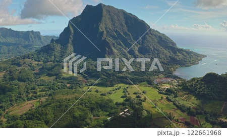 Aerial view revealing stunning beauty of Moorea, French Polynesia, with mount Rotui towering over green hills landscapes and tranquil turquoise water. Wild travel destination, remote nature paradise Aerial view revealing stunning beauty of Moorea, French Polynesia, with mount Rotui towering over green hills landscapes and tranquil turquoise water. Wild travel destination, remote nature paradise 122661968